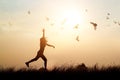 Woman and flying birds enjoying life in nature on sunset