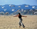 Woman flying with sea birds on the beach