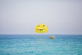 Woman flying on a yellow parachute with smiling face on it Royalty Free Stock Photo