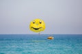 Woman flying on a yellow parachute with smiling face on it Royalty Free Stock Photo