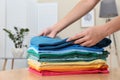 Woman folding bright clothes on table indoors Royalty Free Stock Photo
