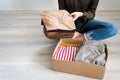 Woman packing clothes into cardboard donation box Royalty Free Stock Photo