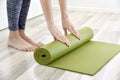 Woman folding yoga or fitness mat after working out at home, Home exercise workout.