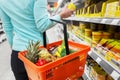 Woman with food basket and jar at grocery store Royalty Free Stock Photo