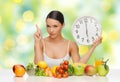 Woman with food and big clock sitting at table Royalty Free Stock Photo