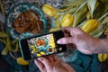 woman food blogger takes pictures of a beautifully set table with yellow tulips Royalty Free Stock Photo