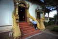 The woman food the dog at the Buddhist temple