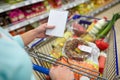 Woman with food in shopping cart at supermarket Royalty Free Stock Photo