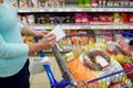 Woman with food in shopping cart at supermarket Royalty Free Stock Photo