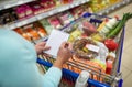 Woman with food in shopping cart at supermarket Royalty Free Stock Photo