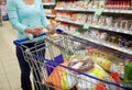 Woman with food in shopping cart at supermarket Royalty Free Stock Photo
