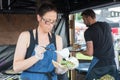 Woman in Food Truck Pouring Dressing onto Veggie Wrap
