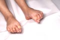 Woman foot flexion on bed sheets