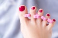 Woman foot pedicure done at home by herself with nail separators and red nail polish