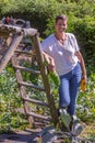 Woman on foot, picling in a vegetable garden