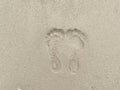 Woman footprint stamp on sand ground at the beach. Rough surface texture.