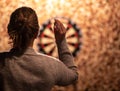 A Woman Readies a Dart and Aims at the Board