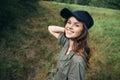 Woman in the forest Cheerful smile green suit black cap cropped look travel