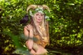 Woman in the forest dressed in skins and fur. On the head of the crown from the horns. Fabulous concept.