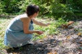 Woman in the forest feeds a manual squirrel with hazelnuts, communication with animal