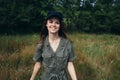 woman in the forest Happy smile green jumpsuit black cap fresh air trees