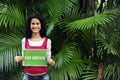 Woman in the forest holding a go green sign