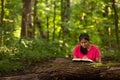 Woman in Forest Preserve with Bible Kneeling in Prayer