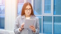 woman in a formal suit and glasses walks and looks at the tablet on the street Royalty Free Stock Photo