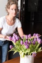 Woman forming bouquet of purple tulips