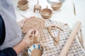 woman forming leaf shaped clay by hands, closeup in artistic studio