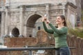 Woman in foro romano takes photos with her smartphone Royalty Free Stock Photo