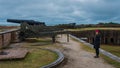 Woman at Civil War Fort standing in front of cannons on the wall