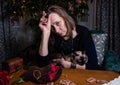 A woman fortuneteller holds in her hand a rune, she looks sad.