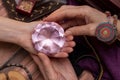 Woman fortuneteller puts a crystal of fate in her hand, a magic ball of predictions. The concept of predicting the future, magic, Royalty Free Stock Photo