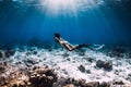 Woman free diver with fins glides underwater in deep blue ocean Royalty Free Stock Photo