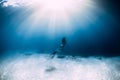 Woman freediver in bikini over sandy sea with fins. Freediving underwater