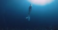 Woman freediver glides on deep ocean. Freediving in blue ocean