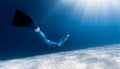 Woman freediver glides over sandy bottom