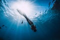 Woman freediver relax with fins underwater. Freediving girl and beautiful light in blue sea