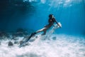 Woman freediver swim underwater over sandy bottom with sand