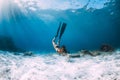 Woman freediver with white sand over sandy sea with fins. Freediving underwater