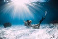 Woman freediver with white sand over sandy sea with fins. Freediving underwater