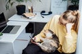 Woman freelance or procrastinate at workplace at home office. Self-employed businesswoman with cat distracted from work Royalty Free Stock Photo