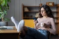 Woman freelancer procrastinate from work. Female distracted from laptop scroll social media on phone