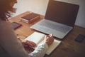 Woman freelancer female hands with pen writing on notebook at home or office. Royalty Free Stock Photo