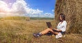 Woman freelancer In Harvested Field working with laptop Royalty Free Stock Photo