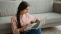 Woman freelancer smiling Arabian Indian girl on floor businesswoman working from home typing message on laptop studying Royalty Free Stock Photo