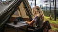 Woman freelancer working remotely with laptop and enjoying breathtaking mountain landscape