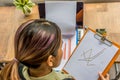 Asian freelancer working on sales diagram documents on rustic table