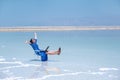 Woman freelancer works at a laptop on the shores of the dead sea in israel Royalty Free Stock Photo